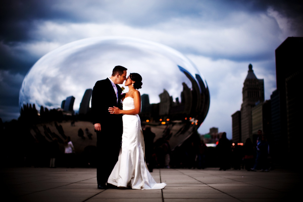 wedding photo by Kevin Weinstein Photography - bride and groom kissing in front of Chicago's cloud gate sculpture